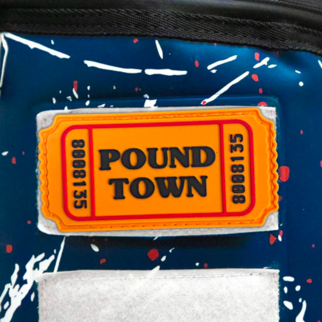Bright orange Pound Town Velcro patch with bold black lettering, affixed to a blue and white splattered background.
