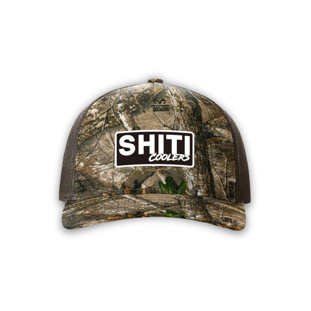 Realtree Edge camo hat featuring a prominent SHITI Coolers logo on the front. Ideal for outdoor enthusiasts.