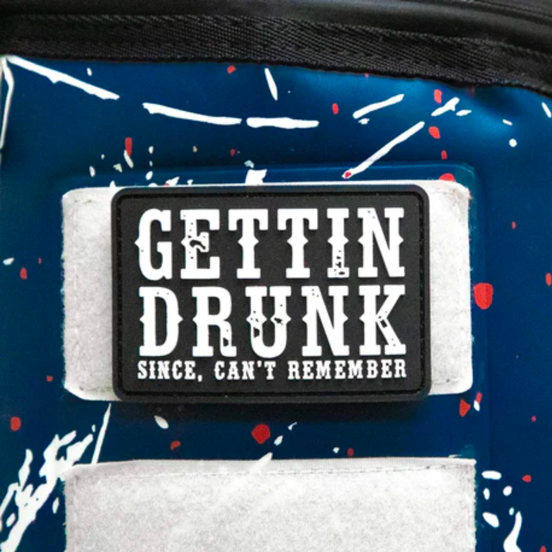 Black Velcro patch with white text reading &quot;GETTIN&#39; DRUNK SINCE, CAN&#39;T REMEMBER&quot; on a colorful splatter background.