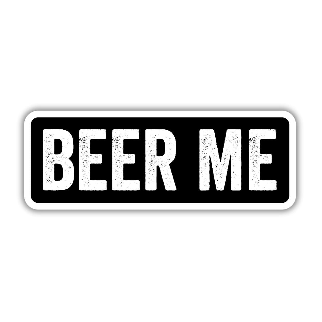 Black rectangular sticker with bold white text that reads "BEER ME," featuring a distressed texture.