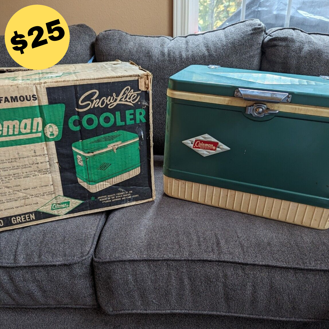 Vintage Big Green Cooler next to its original box, showcasing a classic design with a metal exterior and a sturdy handle.